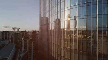 Modern ofis binasının dışında camdan ve çelikten aynalarda şehir yansıması, finansal bölgenin çağdaş mimarisi. Yüksek kalite 4k görüntü