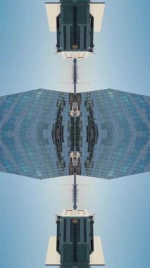 Modern uzun gökdelen binasının ve şehir ortamının ayna fraktal etkisi simetri camı ve metal dış görünüş, teknolojik soyut arka plan, büyüleyici. Yüksek kaliteli görüntüler, 4k dikey video