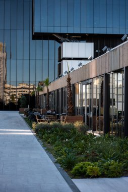 Camdan cepheli modern mimari ve açık hava terası parlak gün ışığında canlı şehir ortamında kafeler, Madrid Cuatro Torres bölgesinde gökdelen. Yüksek kalite fotoğraf