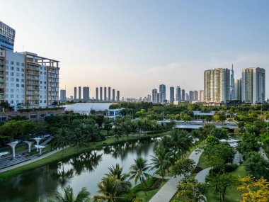 Gökdelenleri ve çağdaş mimarisi olan, Ho Chi Minh semtinde yeşil çimenleri ve palmiye ağaçları olan modern yeşil şehir parkı. Yüksek kalite fotoğraf