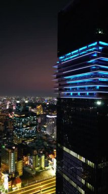 Aydınlatılmış Ho Chi Minh şehir silueti ve Saigon nehri, şehir merkezinin neon sokak ışıkları gökdelen kuleleri, Vietnam hava aracı manzaralı. Yüksek kalite 4k görüntü, dikey video