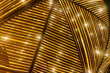 Bambu dokusu sıcak ışıklarla parlar, kırsal arka plan ve sanatsal cazibe yaratır, ahşap levhalar akşam aydınlatması altında doğal güzellik ve ambiyansı yayarak desen örer. Yüksek kalite fotoğraf