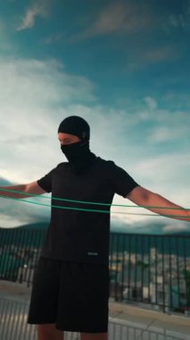 Güneş batarken çatıda ip atlayan vücut geliştirici atlama antrenmanı güneş batarken çatıda ip atlama antrenmanı yapan sporcu. Yüksek kalite 4k görüntü, dikey video