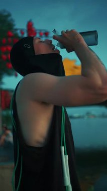 Antrenmandan sonra atlama halatıyla atlayan erkek vücut geliştiriciyi hoş karşılayan sporcu, teneffüste atlama halatıyla omzuna su dökerek dinleniyor. Yüksek kalite 4k görüntü