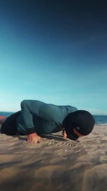 Erkek vücut geliştirici, gün batımında kumsalda şınav çekiyor erkek sporcu, gün batımında kumlu sahilde şınav çekiyor. Yüksek kalite 4k görüntü