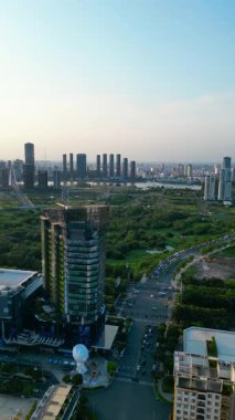 Ho Chi Minh şehir silueti ve Saigon nehri üzerinde güzel bir günbatımı yeşil tropikal park ve gökdelenleri ve Vietnam hava manzaralı şehir merkezi bölgesi. Yüksek kalite 4k video, dikey görüntü