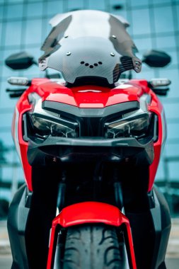 Saldırgan bir ön görüş tasarımına sahip şık kırmızı spor motosiklet, modern kırmızı motosiklet ya da parlak farlar ve parlak bir stil sergileyen scooter. Yüksek kalite fotoğraf