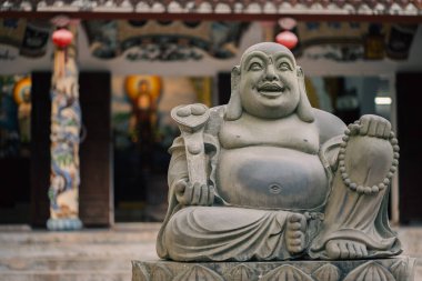 Tapınağın girişinde Lotus üssü olan Hotei Buda heykeli sıcak ışık altında, manevi ambiyansı olan süslü tapınağın önünde Hotei 'nin kutsal heykeli. Yüksek kalite fotoğraf