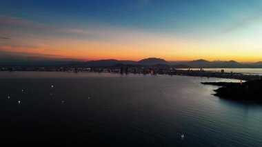 Gün batımında Da Nang şehrinin insansız hava aracı manzarası sakin güzellik ve şehrin ufuk çizgisi, Danang kıyısı ve alacakaranlıkta liman, sakin sular ve şehir cazibesi. Yüksek kalite 4k görüntü