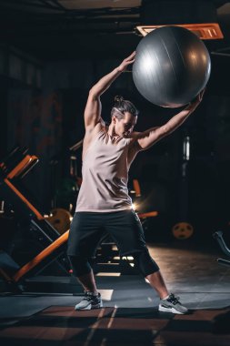 Spor salonunda vücut geliştirme antrenmanı, spor yaparken spor topuyla egzersiz yapan bir adam. Yüksek kalite fotoğraf