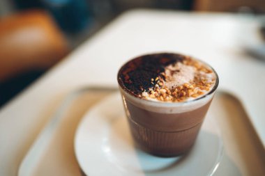 Kafede fındıklı hindistan cevizi gevreği, sıcak bir hoşgörü ve rahat bir lezzet, üzerinde fındık parçacıklı çikolata içeceği kafeteryada hindistan cevizi dilimlenmiş. Yüksek kalite fotoğraf