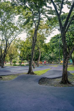 Çocuklar için parkta kayak yolu, güvenli oyun alanında scooter ya da bisiklet kullanan çocuklar için yumuşak pist. Yüksek kalite fotoğraf