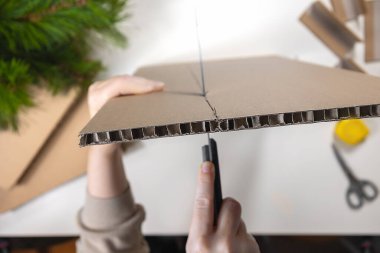  Masanın üzerinde oyulmuş karton, makas ve mezura var. Kalın kıvrımlı karton bir tahtanın yan görünüşü. Adım adım fotoğraflarım. Adım 3