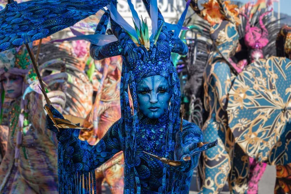 Menton, Fransa-12 Şubat 2023: Renkli blu, fantastik karnaval kostümü giymiş, geleneksel Lemon Festivali sırasında şemsiye yürüyüşü yapan bir kadın..