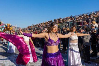 Menton, France-February 12, 2023: Close up woman dressed colorful carnival costume dancer dancing during the traditional carnival parade of Lemon Festival.