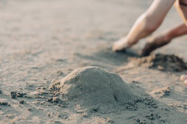 Seçici odaklanma, yaz kumsalında kumla oynayan çocukların elleri. Tatil kavramı