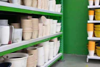 Bahçıvanların ihtiyaçlarını karşılamak için çeşitli boylarda ve renklerde bir bahçe mağazasında düzenli bir şekilde seçilmiş bitki saksısı seçimi..