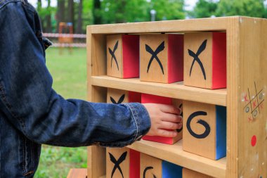 Açık havada tahta Tic-Tac-Toe oynayan çocuğun yakın çekimi. Oyuncu ve eğitici eğlence ve açık hava aktivitesi.