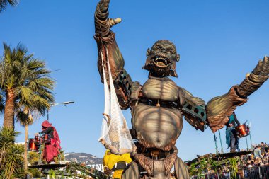 Menton, Fransa-12 Şubat 2023: Dev animatronik goril figürü ve geleneksel karnaval geçit töreni davulcuları Rock ve Opera temalı