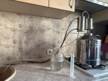 Moonshine hala bir mutfak sobasında çalışıyor, ev yapımı alkol üretiyor. Tüpler ve cam bir kavanoz damıtıcıyı toplar, geleneksel zanaat sanatını gözler önüne serer.