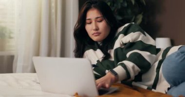 Dizüstü bilgisayar sorunları. Bir kadın yatağa uzanıyor ve bilgisayarın başında çalışıyor. Kız sinirleniyor çünkü donanım çöktü virüs sistemi hacklendi, hata yaptı, belgeler silindi.