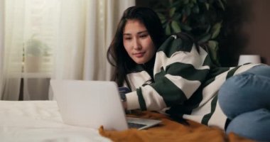 Neşeli kadın mağazaların internet sitesinden satın almalar için çevrimiçi ödeme yapıyor. Kız ona büyük bir indirim yapan bir indirim kodu kullanıyor, çok mutlu..