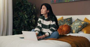 Genç bir öğrenci dizüstü bilgisayarlı bir odada bir yatakta oturuyor ve sınavlara çalışıyor. Kadın geçen bir not için proje yazıyor. Konuyla ilgili harikalar yaratıyor..