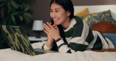 Asyalı gibi gülümseyen arkadaş canlısı bir kadın laptop kamerasıyla başka bir ülkeden bir arkadaşını selamlıyor. Kadınlar sosyal ağda görüntülü sohbet yoluyla sohbet ediyorlar..