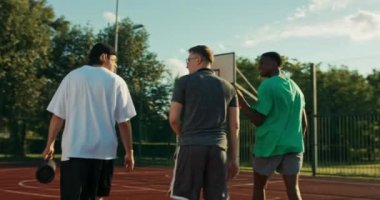 happy friendship concept. Young guys in sportswear spend time at playground outdoors african american man shows skills trains friends activity sport concept outdoors.