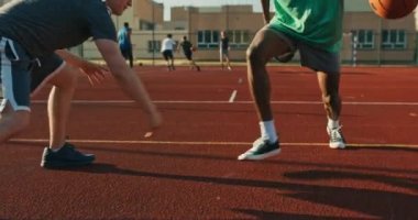 Selective focus african american man in sportswear professional trainer plays with friends at playground spends time together shows skills. Happy friends company at weekends . Man tries do slam dunk.