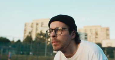 Young handsome concentrated basketball player hipster in stylish fashionable sportswear tried to make slam dunk plays basketball with friends.