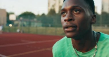 Seçici odaklı Afro-Amerikan konsantre basketbol oyuncusu oyun sahasında arkadaşlarıyla oynayarak smaç basmaya çalışıyor..