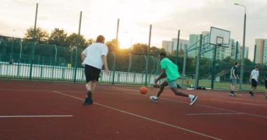 Mutlu Afro-Amerikalı arkadaş arkadaşlarıyla basketbol oynuyor. Birlikte zaman geçiriyorlar. Sayı yapmaya çalışıyorlar. .