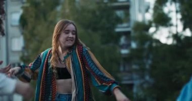 Yavaş çekim, şık giyinen, dans eden, dışarıda müzik dinleyen ve aksiyon hareketleri sergileyen kızlara odaklan..