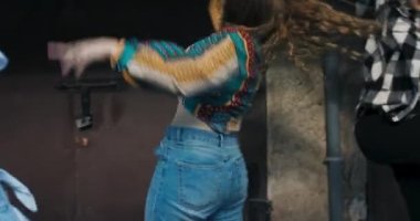 Yavaş çekimde şık giyinen, moda düşkünü, şık bir kıza odaklan dans yeteneğini göster, sokak danslarında takımla dans et. .