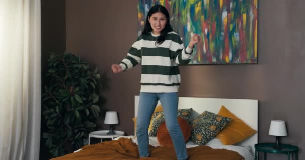 Kız Başarısını Bir Odada Tek Başına Kutluyor Zıplıyor Yatakta Dans — Stok video