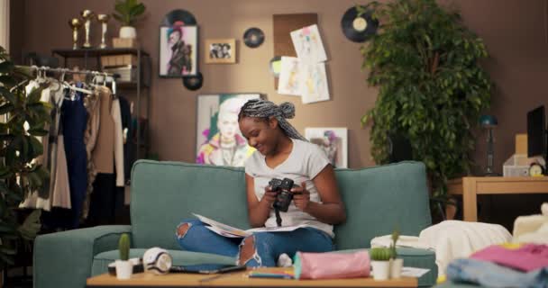 Afrikanerin Sitzt Gemütlich Ihrem Wohnzimmer Mit Einem Stapel Skizzen Auf — Stockvideo