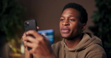 Podcast sunucusu Afrikalı Amerikalı adam cep telefonuyla canlı konuşmaları kaydediyor. Konuklarla röportaj yapıyor. İçsel içeriği paylaşıyor..