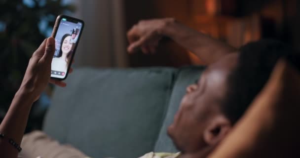 Afrykanin Spoczywa Kanapie Salonie Wykonując Ożywioną Rozmowę Wideo Swoimi Przyjaciółmi — Wideo stockowe