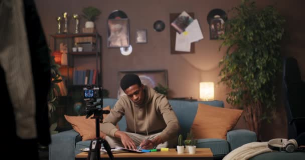 Afrikkalainen Amerikkalainen Sanaseppä Istuu Sohvalla Laittaa Kynän Paperille Käsityö Mukaansatempaava — kuvapankkivideo