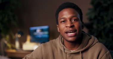 Fitness koçu Afrikalı Amerikalı adam müşterilerine cep telefonuyla fitness hedefleri için koçluk yapıyor, kişisel planlar sunuyor, ilerlemeyi takip ediyor ve gülümseme ve enerjik danslarla destek veriyor..