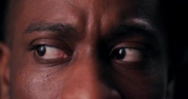 Afro-Amerikalı bir adamın rahatsız edici yakın plan çekimi insanın deneyiminin saf korkusunu ve savunmasızlığını aktarmak için omurgadan aşağı titreme gönderir..