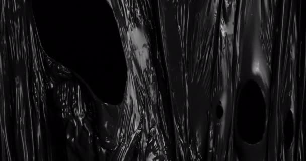 深みのある黒を背景に伸縮性のあるプラスチックフィルムの魅惑的な質感を探索し 食品の包装に一般的に使用される砕いたセロハンラップを連想させます — ストック動画
