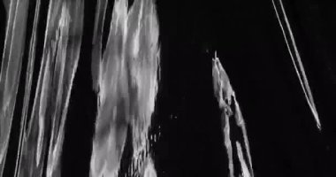 Kendini, esnetilmiş plastik bir film dokusunun, siyah bir zemin üzerine kurulmuş benzersiz görsel deneyimine daldır. Yiyecek ambalajlarında kullanılan buruşmuş selofan ambalajını anımsatıyorsun..