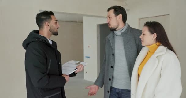 与房地产经纪人交谈后 夫妇们完成了对出售公寓的观摩 一个女人和一个男人和一个开发者讨论 — 图库视频影像
