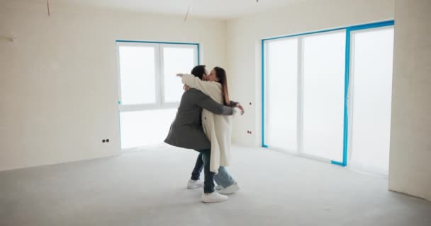 Ett Förälskat Par Står Mitt Tom Lägenhet Och Njuter Köpet — Stockvideo