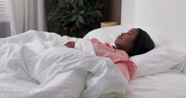 早上醒来 睡在舒适温暖的床上 一个女人醒了过来拖着自己睡了一个长夜 和平的睡眠 — 图库视频影像