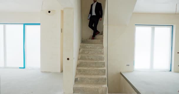 不動産の中東エージェントは 潜在的な顧客に新しいモダンな夢の家を示す手で計画しています 販売のための建物 — ストック動画
