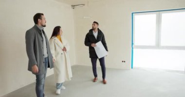 Evli bir çift satın almak istedikleri yeni bir eve bakıyor. Emlakçı onlara teklifi sunar, odaları gezdirir, büyük balkon pencereli güzel bir teras gösterir..