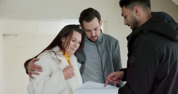 不動産エージェントが家を購入することに興味のある家族とアパートを訪問し インテリアデザインプランを議論 — ストック動画